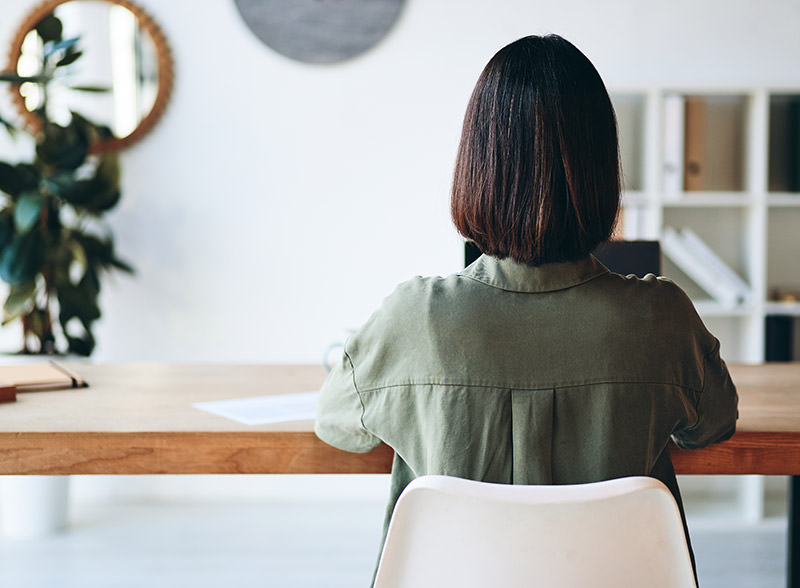 How to adjust office chair: woman sitting at desk