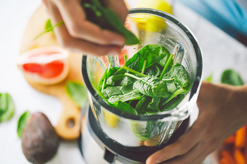 Woman making a healthy weight loss smoothie using blender